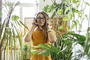 young woman surrounded by plants listening to musi 2022 11 06 23 00 42 utc 1