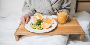 mid section woman having fresh oranges kiwi slices with glass juice bed 1 3